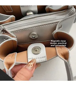 Detail view of silver crossbody bucket bag featuring magnetic closure and inner zipper pocket