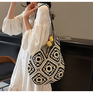 Detail of a handmade boho crochet tote bag with black and white floral patterns