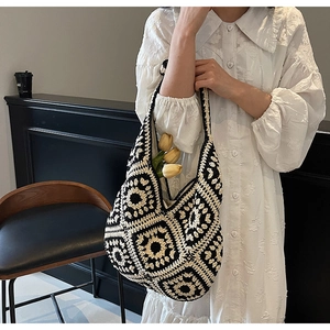 Close-up of black and white crochet patterns on a handmade woven shoulder beach bag