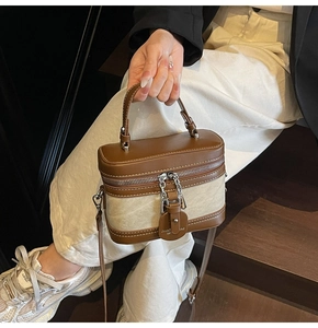 Detail of vintage box-shaped bag featuring brown leather trim and beige canvas texture