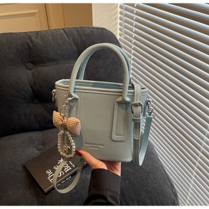 Detail of light blue bucket bag with lychee texture and pearl heart bow charm