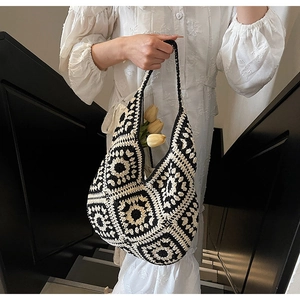 Close-up of retro crochet tote bag with black and white granny square pattern texture