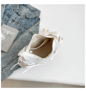 Vue détaillée de l'intérieur du sac bandoulière blanc en nylon avec poche zippée et nœud