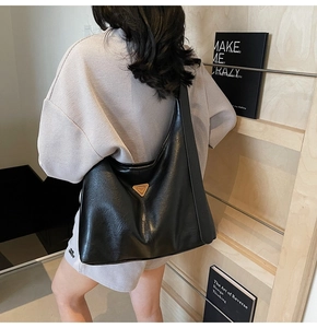 Detail of black large capacity Hobo bag showing the glossy oil wax leather finish and logo
