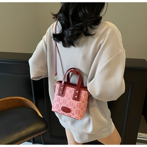 Detail of red bridal handbag with Xi characters and golden hardware on model