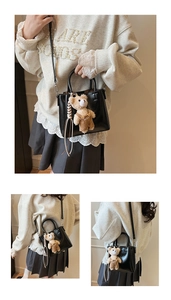 Detail showing a black PU leather bucket bag featuring a cute plush bear charm with SUVS logo