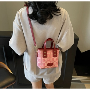 Detail of red wedding bucket bag with Xi character pattern and leather handles