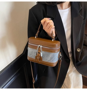 Détail du sac boîte rétro avec patchwork en denim, finitions cuir et chaîne argentée