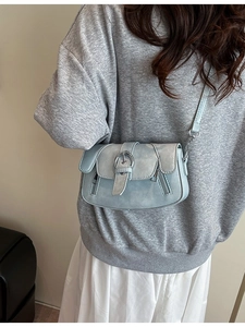 Minimalist grey faux leather crossbody bag with metal ring and shoulder strap on model