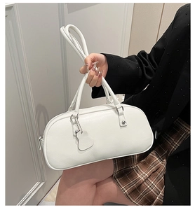 Detailed close-up of a white baguette bag with fine grain texture and silver hardware