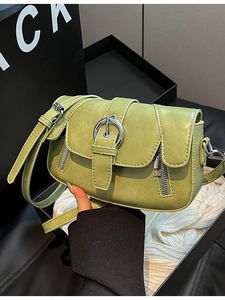 Retro green leather crossbody bag with silver buckle shown in a stylish hand-held pose