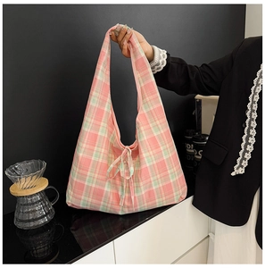 Détail du sac hobo en toile à carreaux rose et vert avec un nœud doux et motif vichy