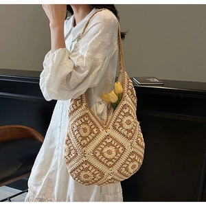 Close-up of bohemian crochet shoulder bag with floral patterns and woven strap detail