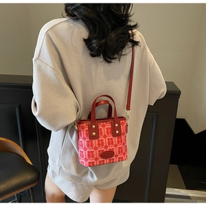 Detail of red bridal handbag with Xi character jacquard and leather shoulder strap