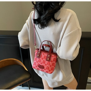 Detailed view of red bridal handbag featuring traditional Xi character embroidery and gold hardware