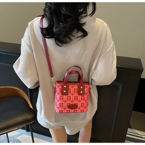 Detail of red bridal handbag with double happiness pattern held by a model