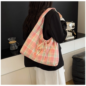Détail du sac cabas en toile à carreaux rose et vert avec nœud décoratif sur l'épaule
