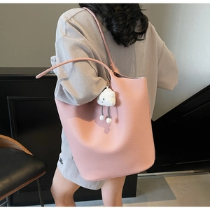 Pink lychee texture bucket bag featuring a white plush cloud charm and long strap detail