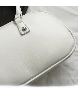 Close-up of premium white leather texture and reinforced stitching on underarm bag handle
