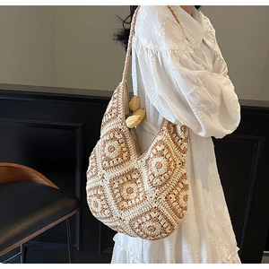 Detail of crochet tote bag with grandmother square floral patterns and warm beige tones