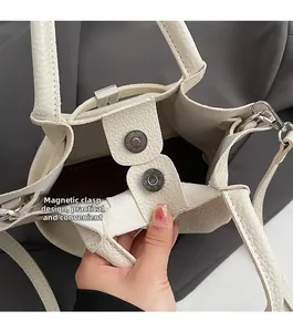 Detail of white lychee textured bag featuring a practical magnetic snap closure