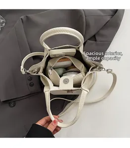 Spacious interior of beige lychee grain leather bucket bag with matching inner pouch