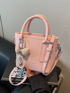 Pink lychee grain leather bucket bag with heart and pearl charm accessories