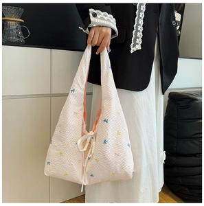Détail du sac cabas en seersucker rose avec nœuds brodés colorés et cordon