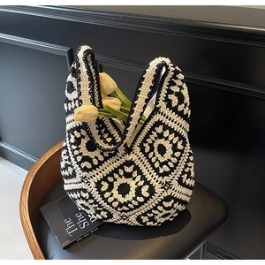 Close-up of black and white hand-crocheted tote bag with geometric floral texture