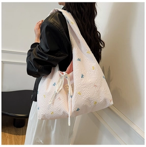 Détail du sac cabas en seersucker rose avec nœuds brodés et rubans blancs décoratifs