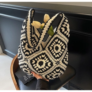 Detailed macro view of handcrafted black and white crochet patterns on a knit tote bag