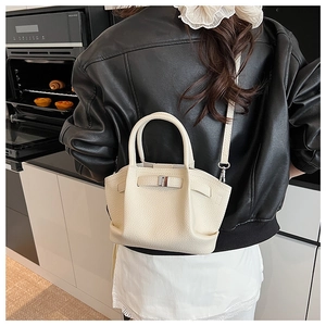 Chic off-white bucket bag with pebble texture and wing design shown as a crossbody bag