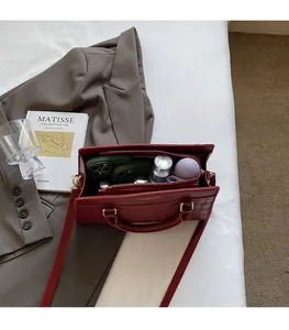 Detail view of red leather handbag interior compartments showing large storage capacity