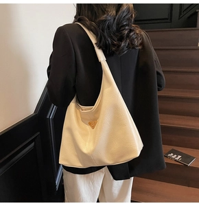 Detail of cream hobo shoulder bag showing large capacity and textured leather finish
