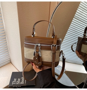 Close-up of vintage brown leather and canvas mini suitcase bag with dual zippers