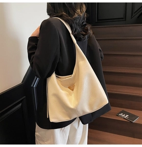 Detail of cream large tote bag with textured faux leather on a model's shoulder