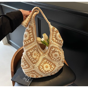 Detail of crochet tote bag with grandmother square floral patterns and a wide strap