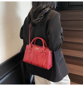 Detail of red wedding tote bag featuring wavy tiger embossing and gold hardware finish