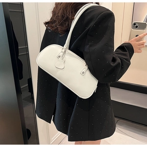 Detail of white minimalist baguette bag with fine lychee texture and thin shoulder straps