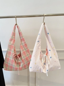 Sacs cabas en toile à carreaux et broderies papillons sur un cintre doré