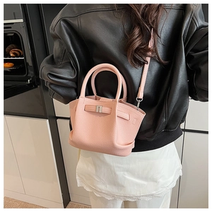 Detail of pink lychee leather mini bucket bag with silver buckle and crossbody strap