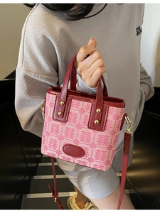 Pink vintage wedding bag with red leather handles and traditional jacquard pattern