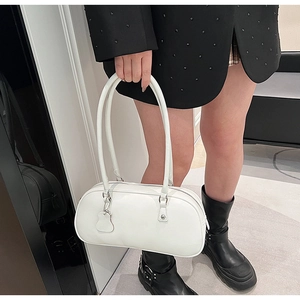 White leather underarm bag shown on model with silver hardware and sleek shoulder strap