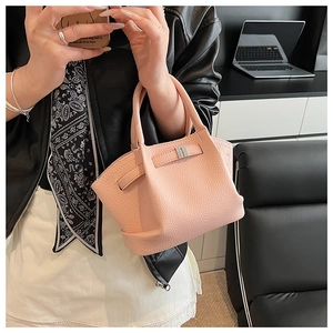 Detail of pink lychee grain bucket bag with silver buckle and leather handle
