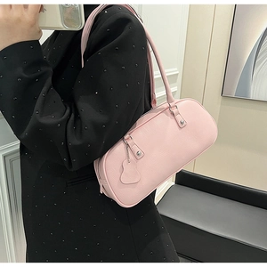 Close-up of pink underarm bag with lychee grain leather texture and silver rivets