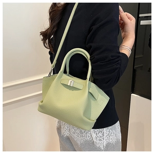 Close-up of light green lychee pattern leather bucket bag with silver buckle detail