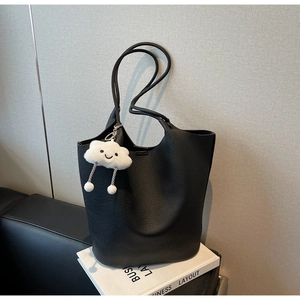 Detailed texture of black lychee grain tote bag with cute cloud plush charm accessory