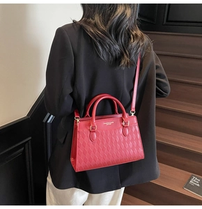Close-up of red quilted leather tote bag with gold hardware and removable strap