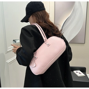 Pink minimalist underarm bag shown on model with polished silver rivet details