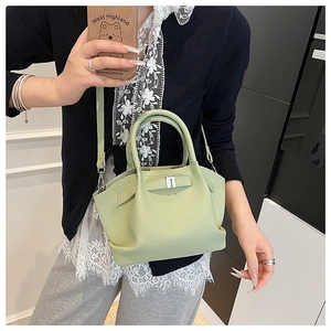 Detail of avocado green litchi grain bucket bag with elegant silver metal buckle